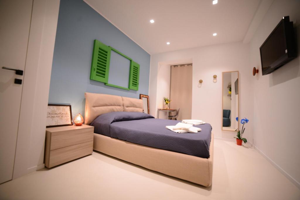 sypialnia z łóżkiem i telewizorem z płaskim ekranem w obiekcie B&B Mareè Seafront Molfetta w mieście Molfetta