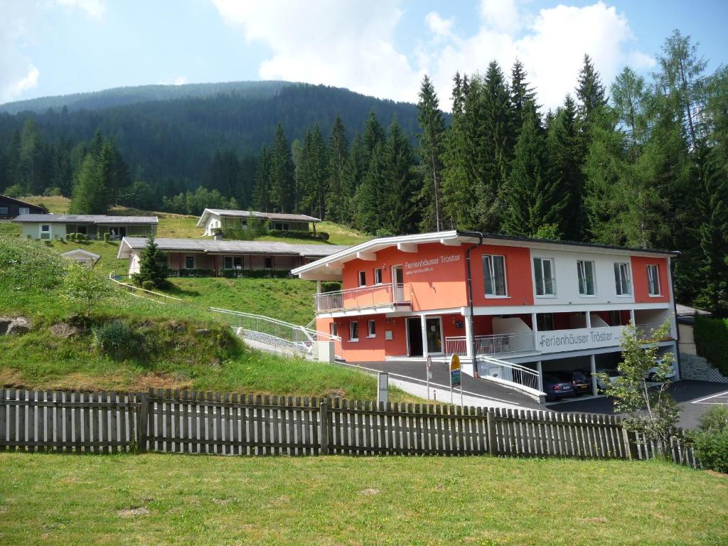 a house on a hill next to a fence at Ferienhäuser Tröster in Bad Kleinkirchheim