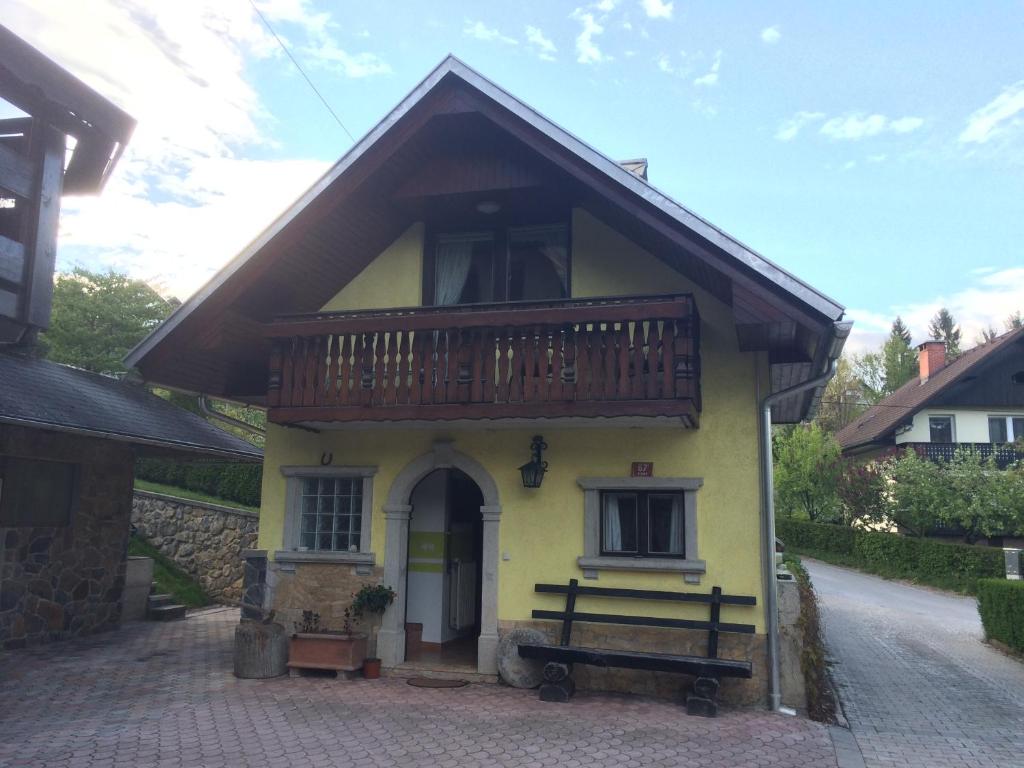 a small yellow house with a balcony on it at Apartma Gracner in Bled