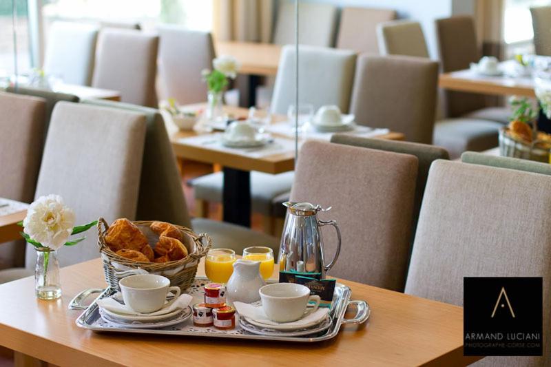 a tray of food on a table with coffee and pastries at Hotel Santa Maria in Saint-Florent