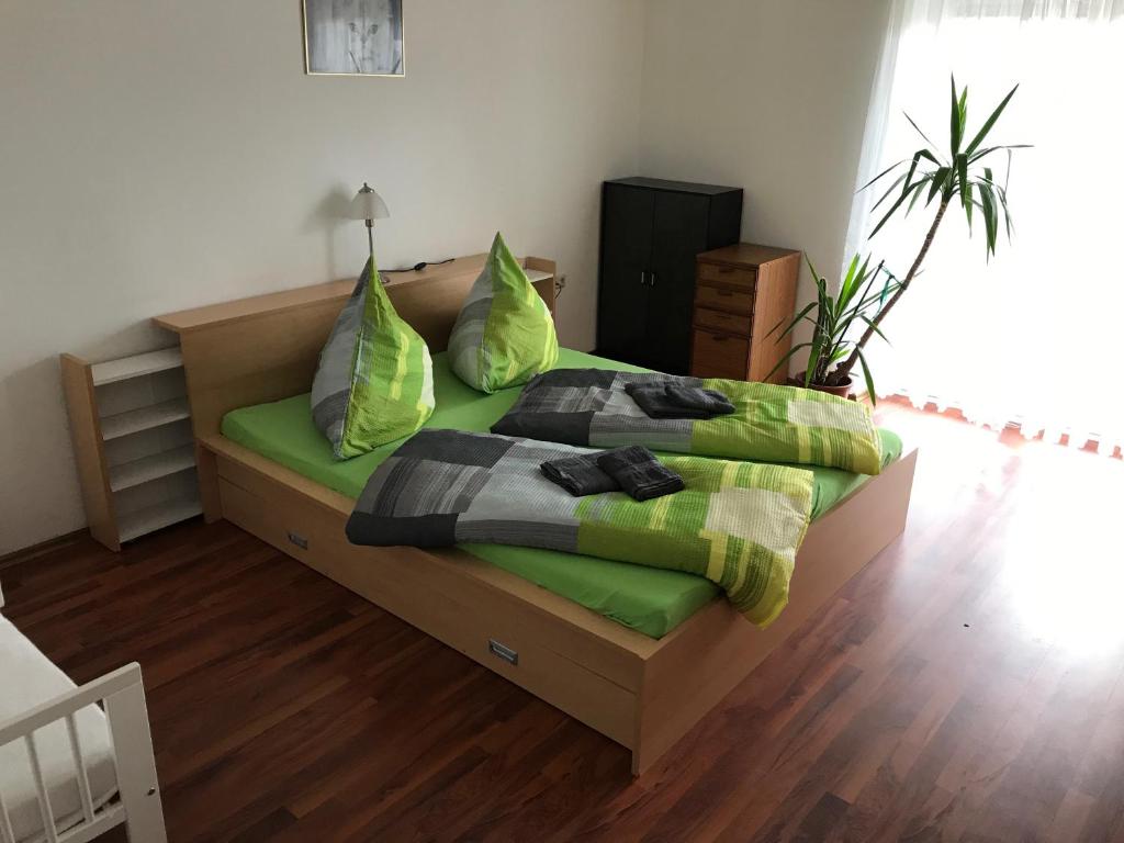 Schlafzimmer mit einem Bett mit grüner Bettwäsche und Kissen in der Unterkunft Haus Johanna in Lechbruck