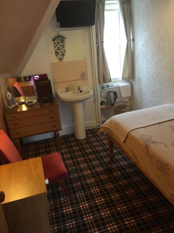 Postel nebo postele na pokoji v ubytování Tanglin Guest House
