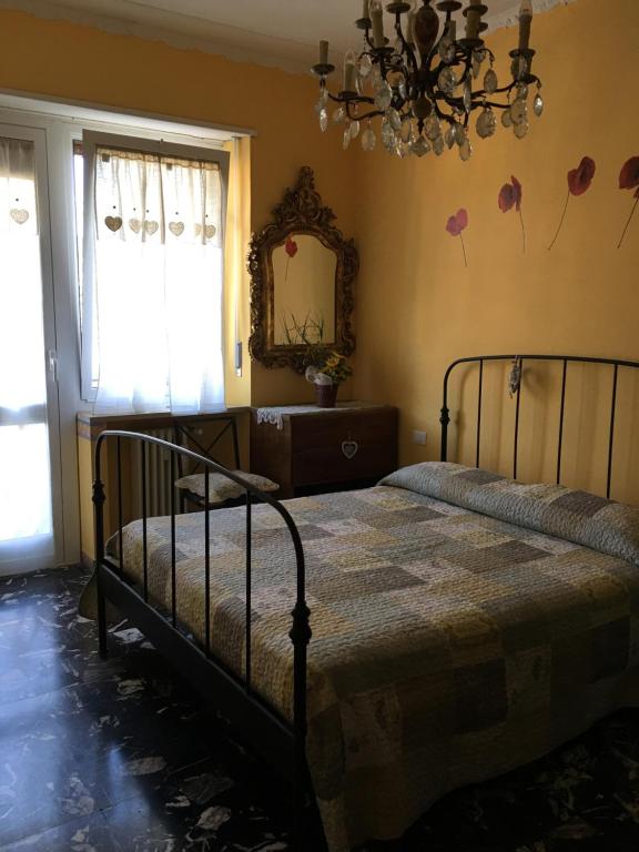 een slaapkamer met een bed, een spiegel en een kroonluchter bij Casa Jacopo in Diano Marina