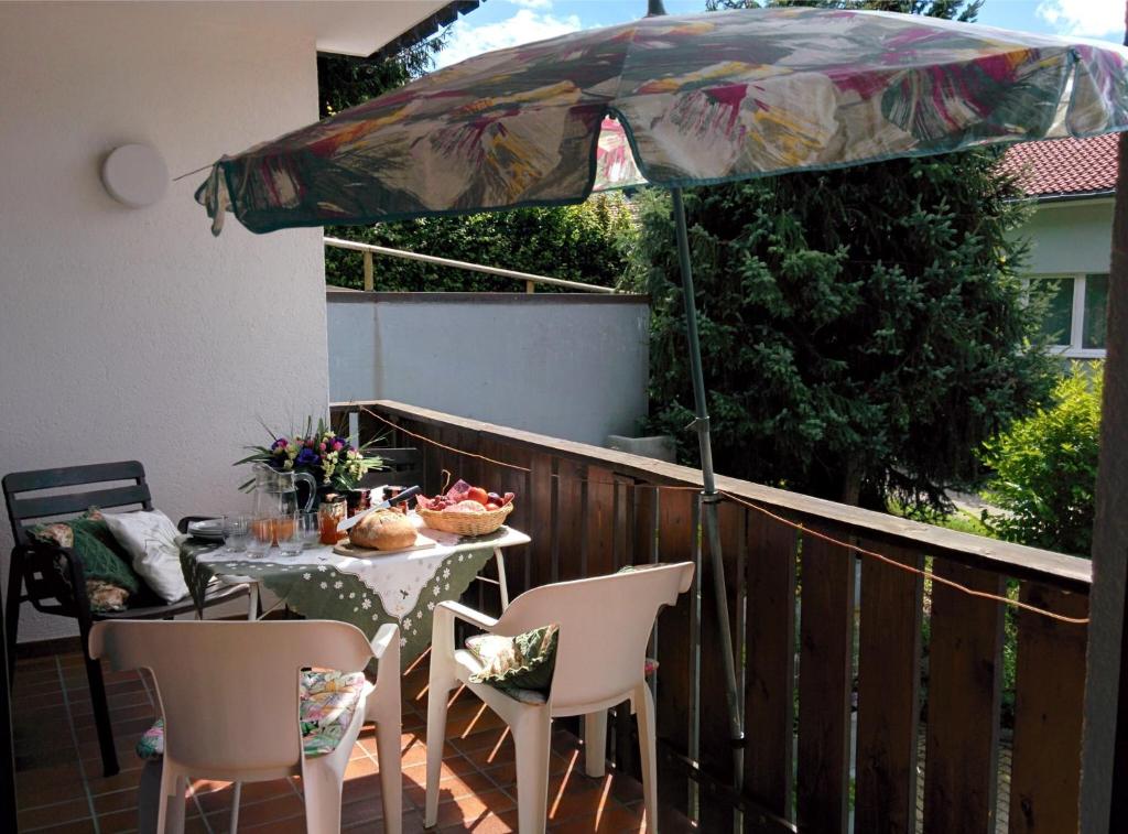 d'une table, de chaises et d'un parasol sur le balcon. dans l'établissement Gib mir funf! Ferienwohnung in St. Blasien, à St. Blasien