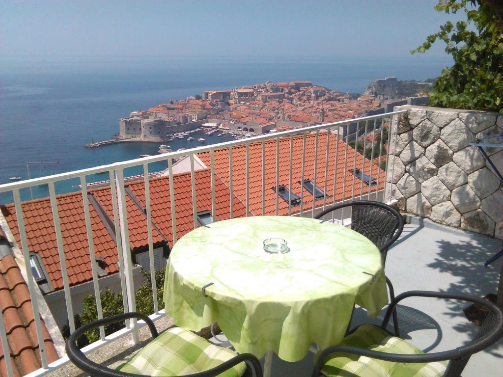 a table and chairs on a balcony with a view of the city at Apartment Luna in Dubrovnik