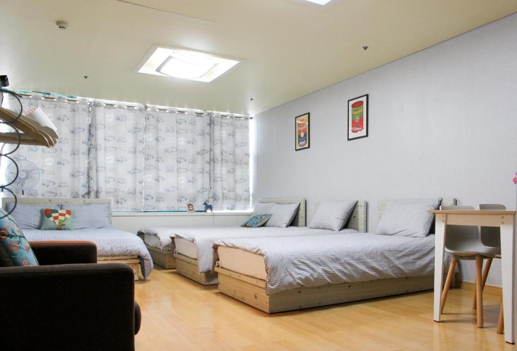 首爾的住宿－弘大薩姆旅舍，一间卧室设有两张床和窗户。