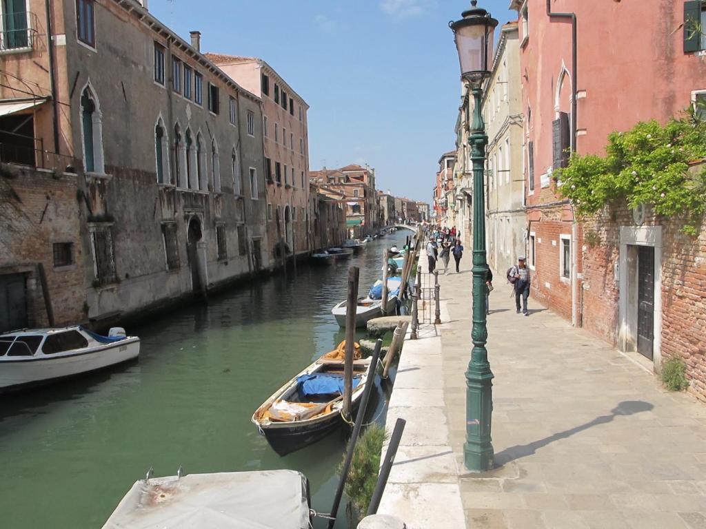 a canal with boats parked on the side of a street at Casa Di PrimaVera in Venice