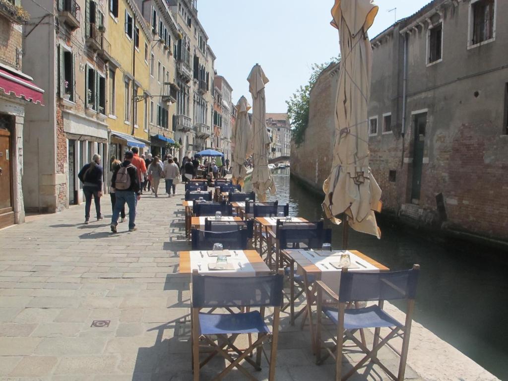 a row of tables and chairs next to a canal at Casa Di PrimaVera in Venice
