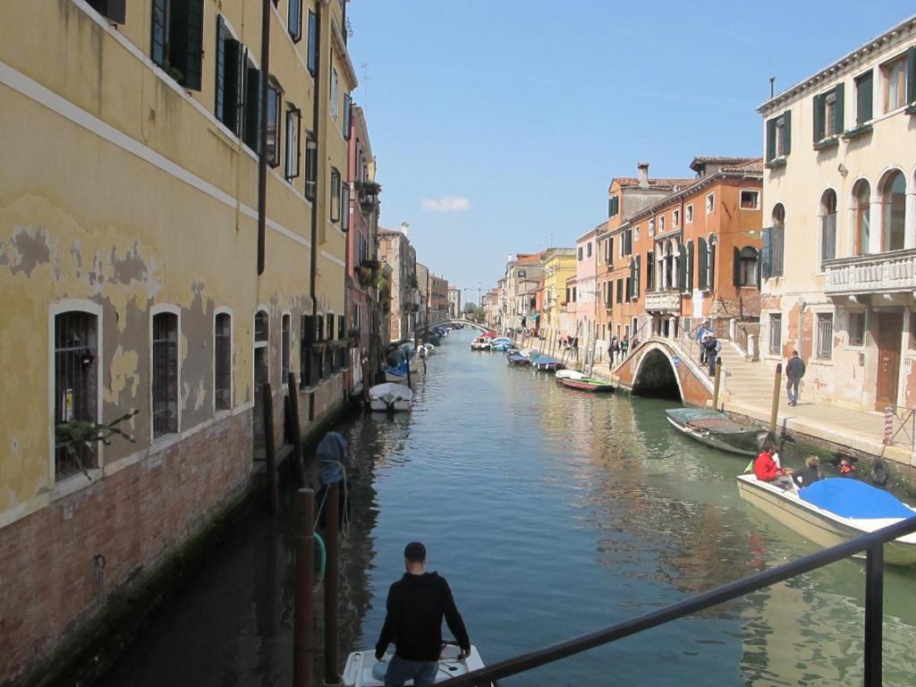 a man is riding a boat down a canal at Casa Di PrimaVera in Venice