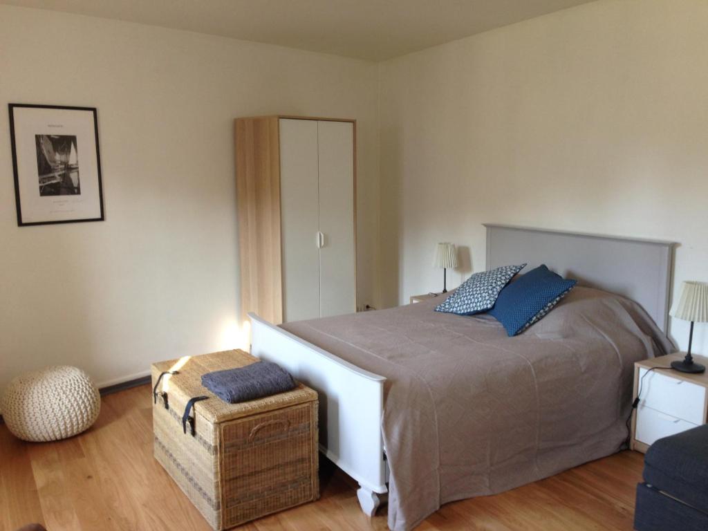 オンフルールにあるUn petit nid a Honfleurのベッドルーム(青い枕の大型ベッド1台付)