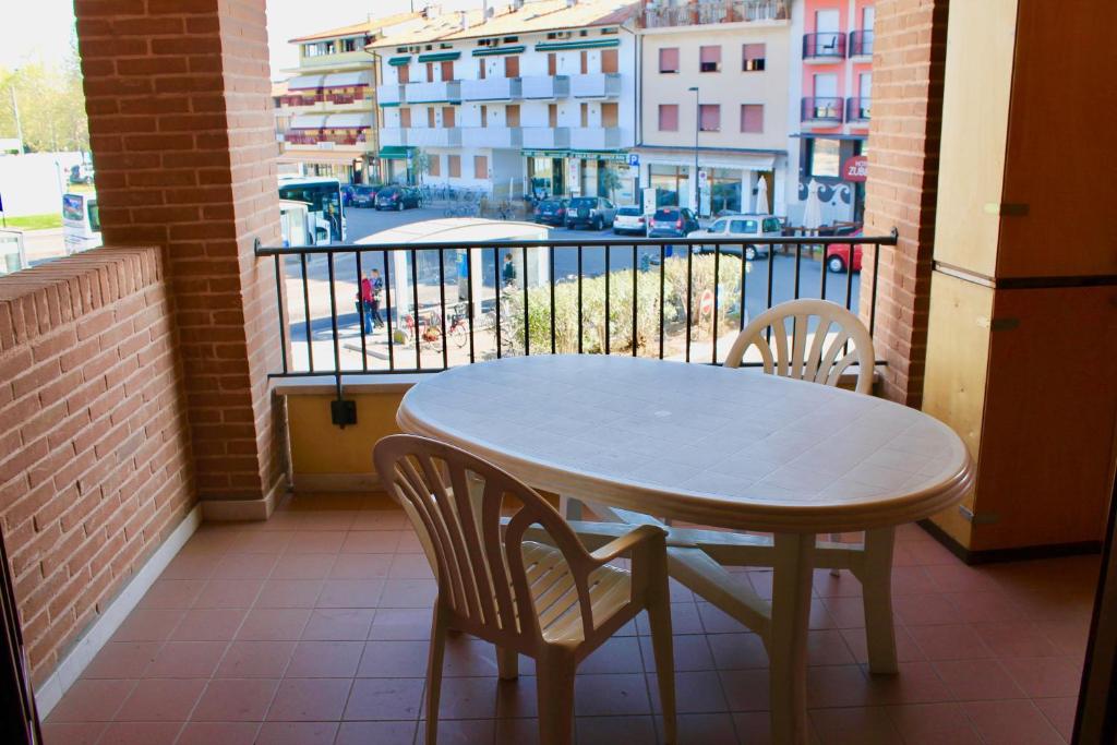 a table and chairs on a balcony with a view of a city at Isola del Sole in Grado