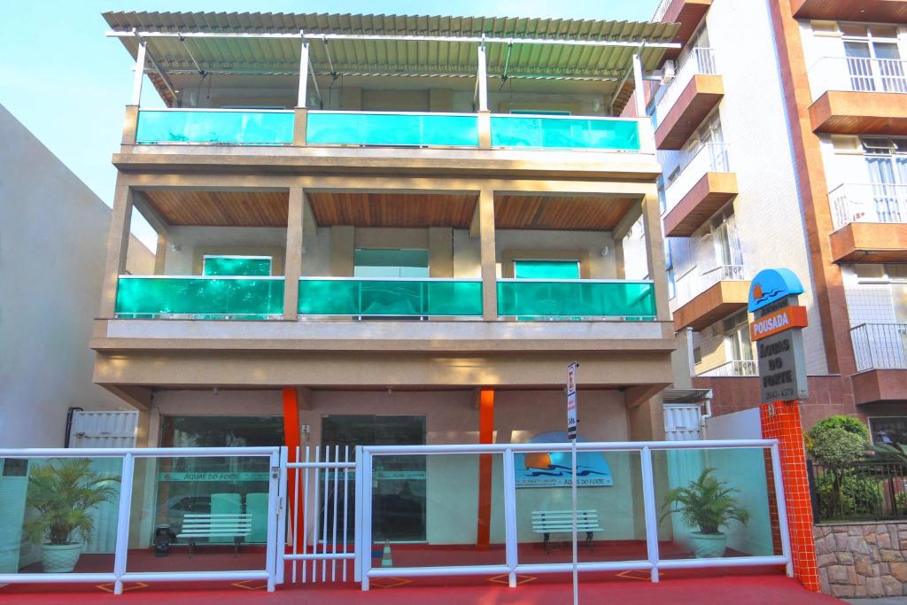 um edifício de apartamentos com uma varanda com cadeiras em Pousada Águas do Forte em Cabo Frio