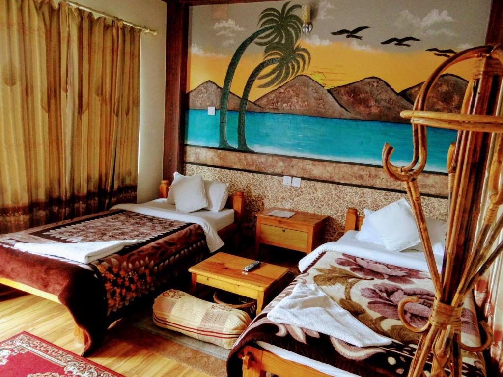 Pokój z dwoma łóżkami i obrazem na ścianie w obiekcie Hotel Hakoniwa w mieście Pokhara