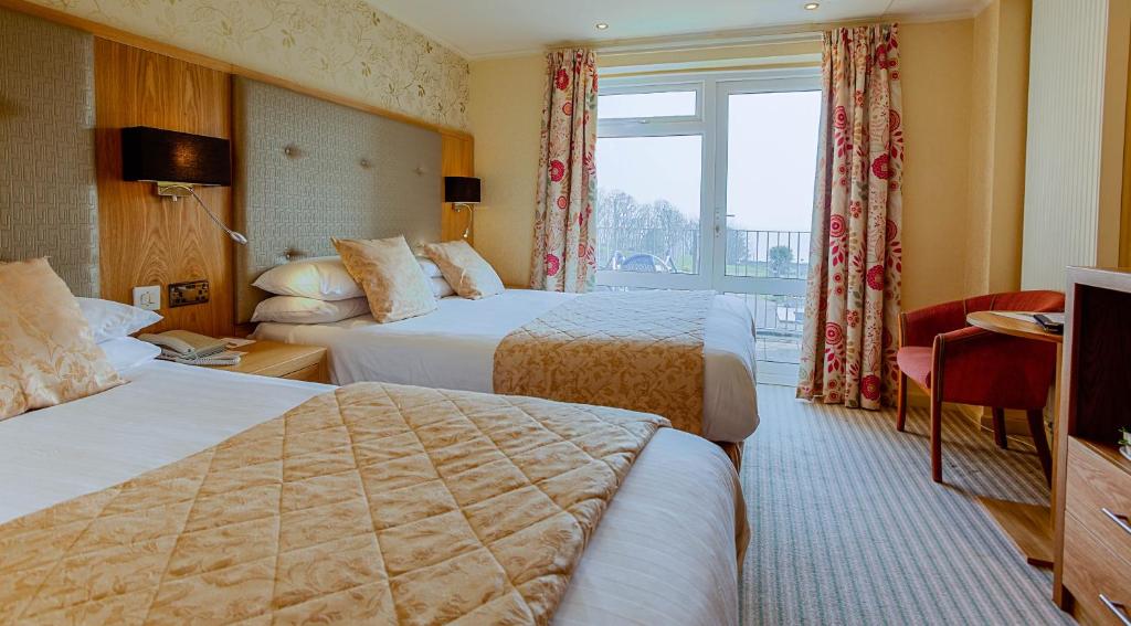 מיטה או מיטות בחדר ב-Langstone Cliff Hotel