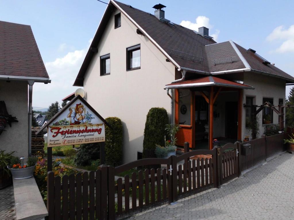 a house with a fence in front of it at Ferienwohnung Langzettel in Oberweißbach