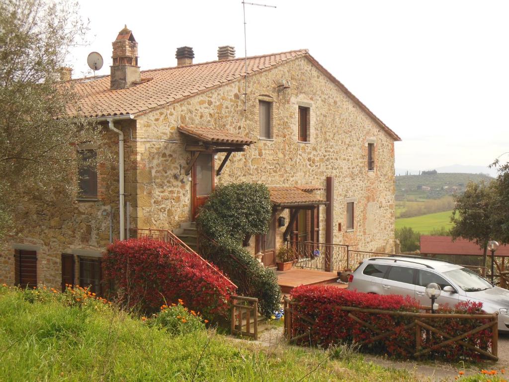 una casa in pietra con un'auto parcheggiata di fronte di Tra lago e collina a Passignano sul Trasimeno