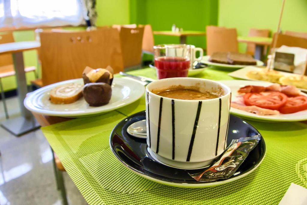 filiżankę kawy na stole z talerzami jedzenia w obiekcie Pontus Veteris w mieście Sanxenxo