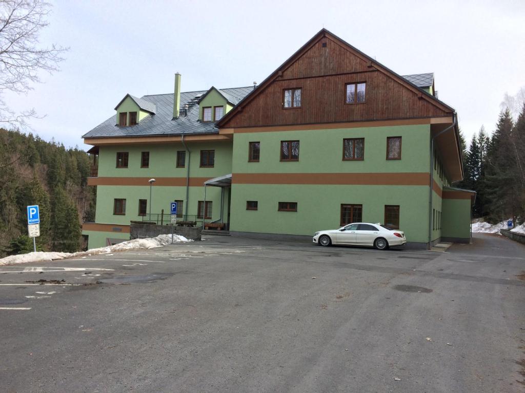 a large building with a car parked in front of it at Orbit Karlov pod Pradědem in Malá Morávka