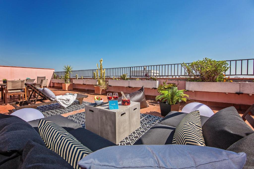 een patio met stoelen en een tafel op een dak bij Sweet Inn - Pedrera Department 24 in Barcelona