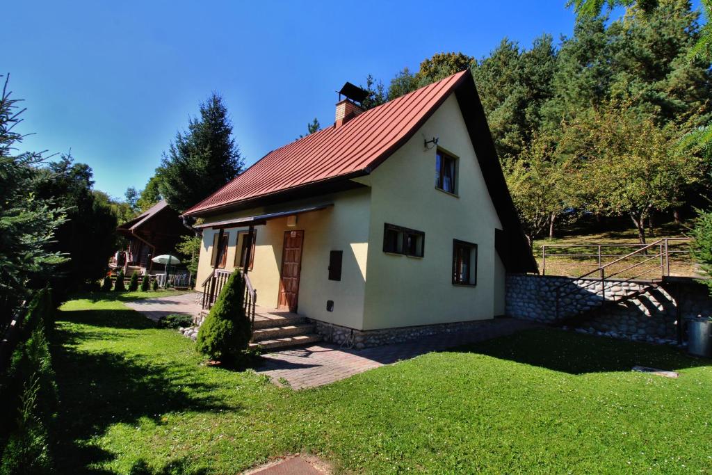 uma pequena casa branca com um telhado vermelho em Chata Martina em Bešeňová