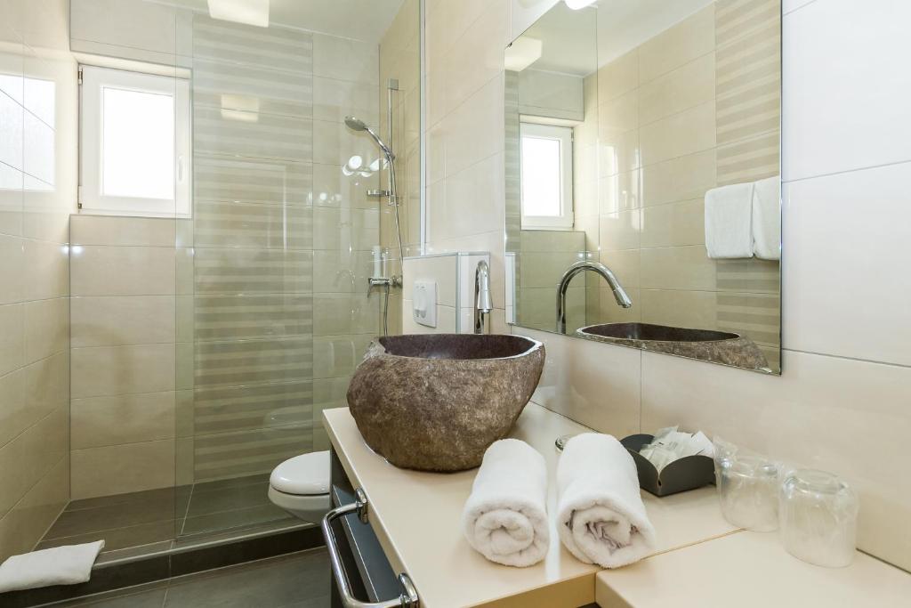 a bathroom with a bowl sink and a shower at Villa Liburnum in Zadar