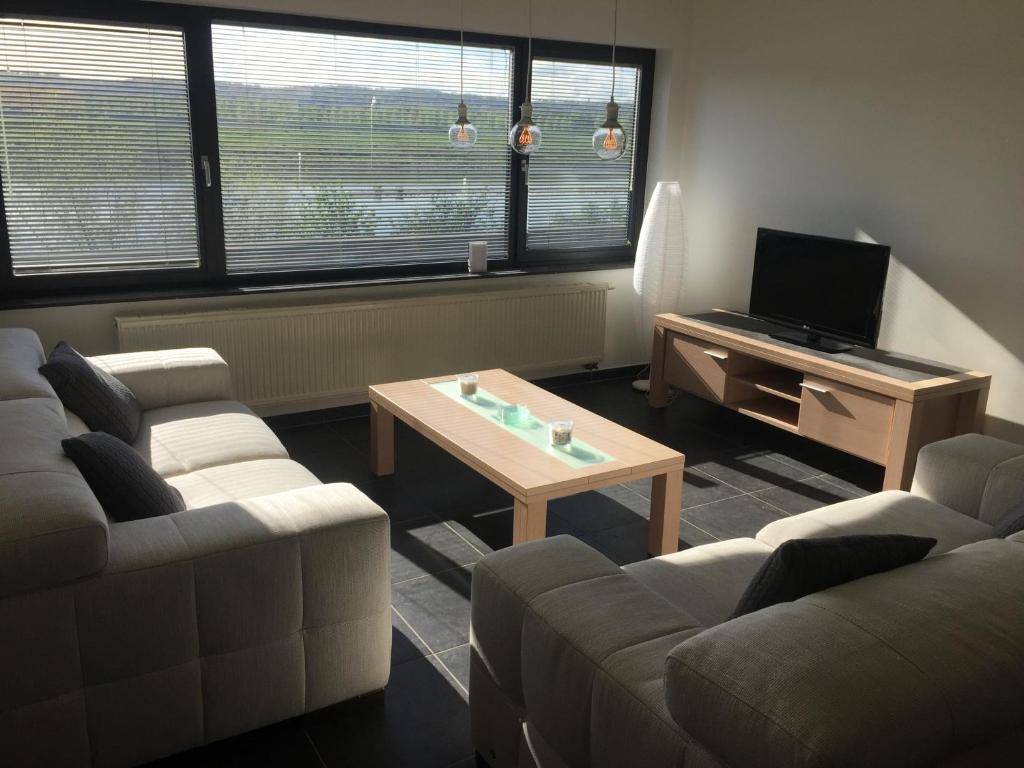 Sala de estar con 2 sofás y mesa de centro en Maaszicht en Maasmechelen