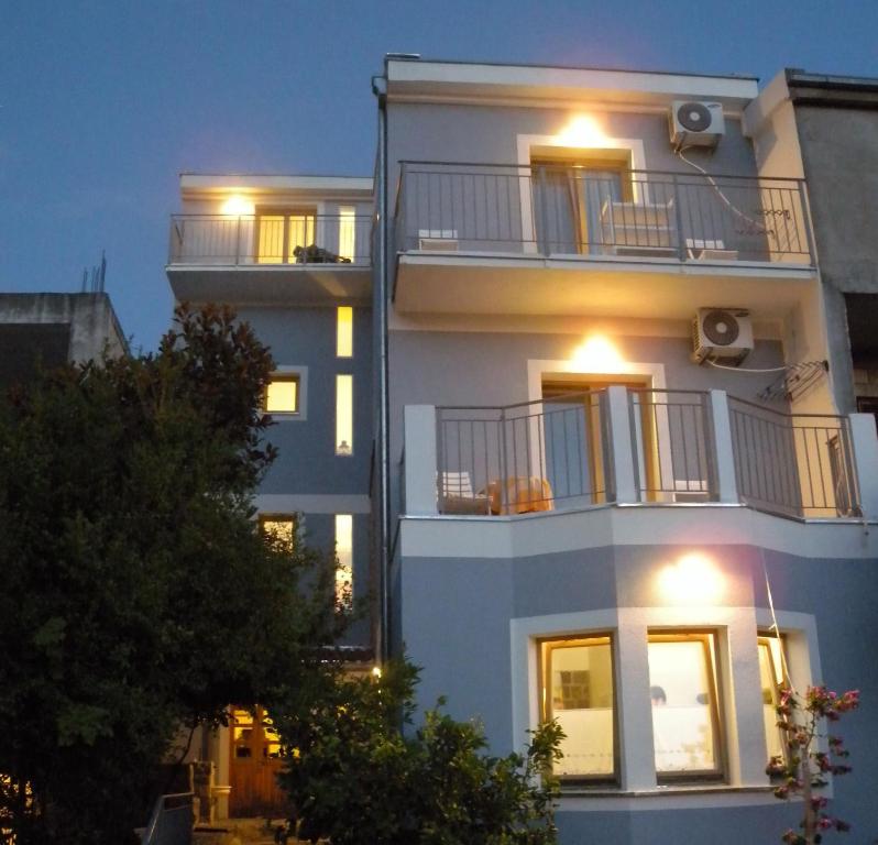 ein weißes Apartmenthaus mit eingeschaltetem Licht in der Unterkunft Apartments Markovic Sutomore in Sutomore