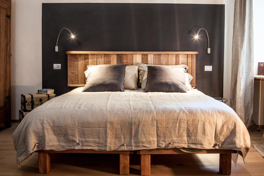 a bedroom with a large bed with a wooden headboard at Virgula B&B in Cuneo