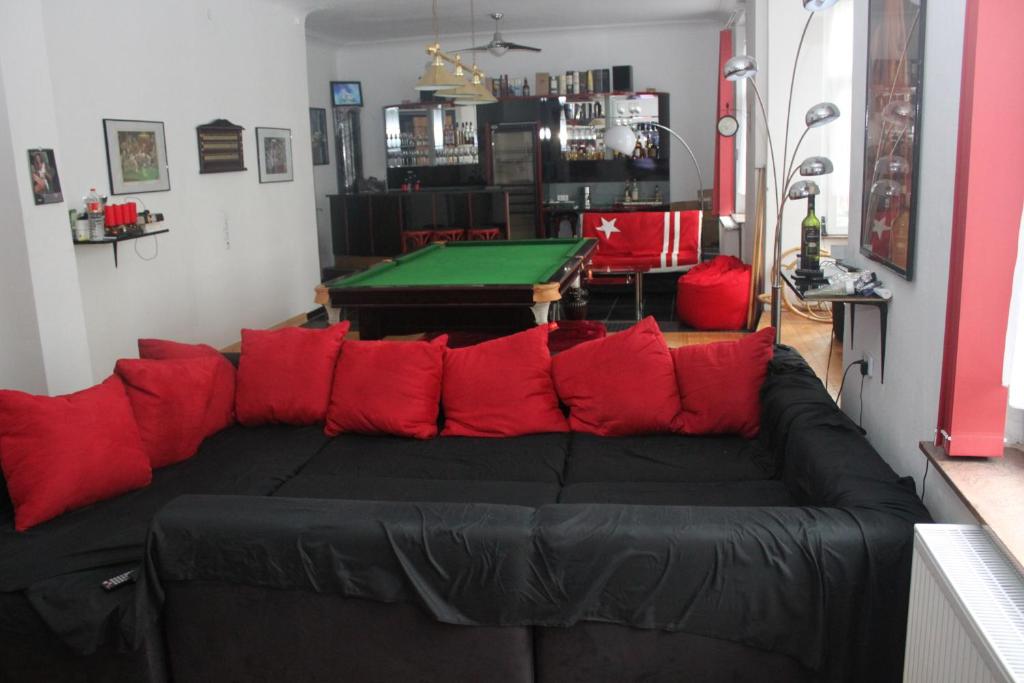 ein Wohnzimmer mit einem schwarzen Sofa und roten Kissen in der Unterkunft Privatzimmer Hagen in Hagen