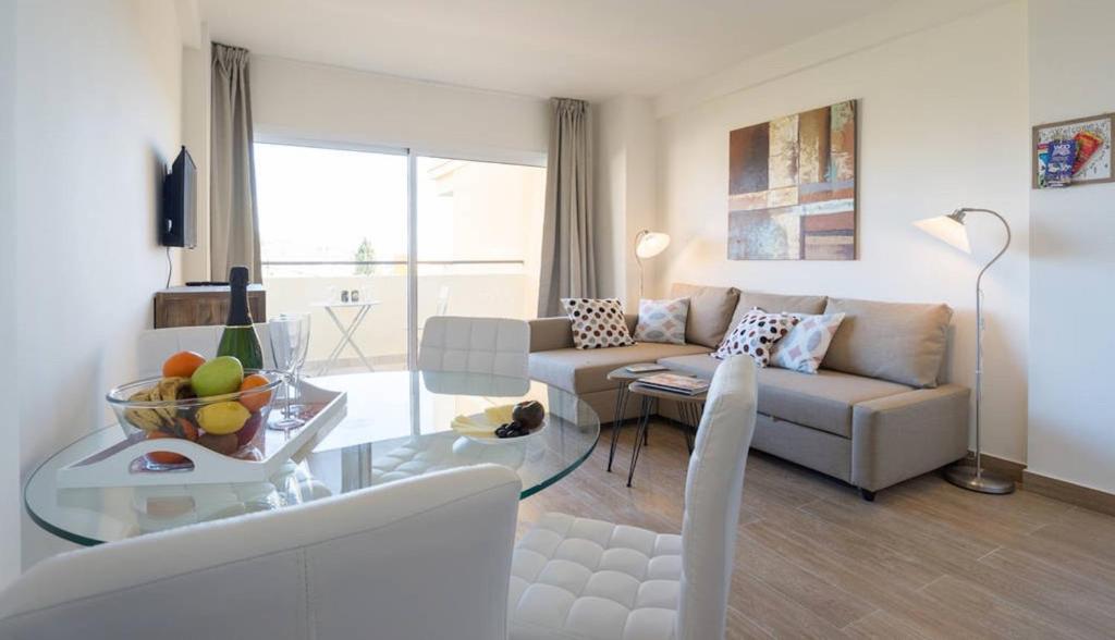 sala de estar con sofá y mesa de cristal en Apartment Club Playa Flores en Torremolinos