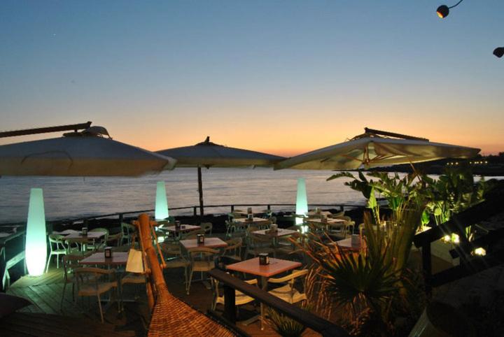 un restaurante con mesas y sombrillas en la playa en Villino Sole, en Pizzo