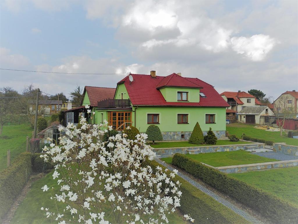 a house with a red roof and some white flowers at Apartmán Vysočina in Zvole