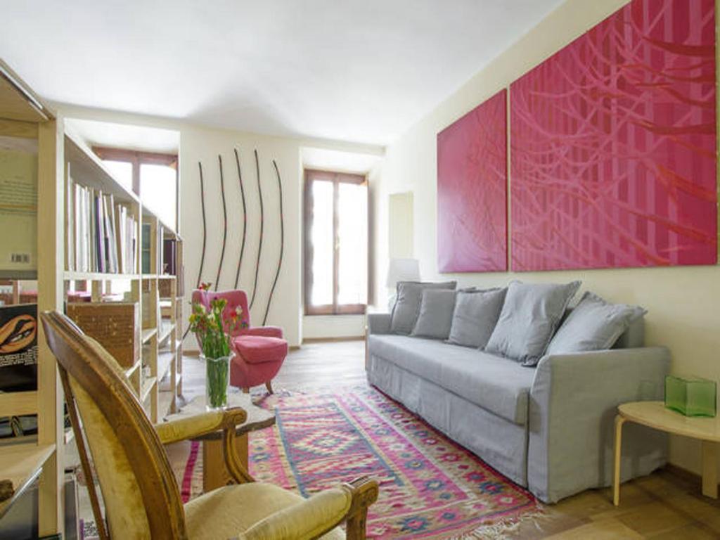 salon z kanapą i czerwoną ścianą w obiekcie Al Portico 39 Apartment w Rzymie