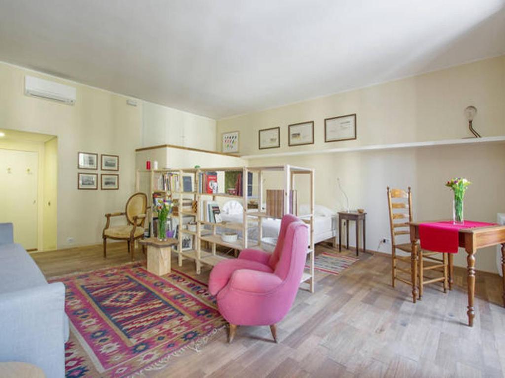 salon z różowym krzesłem i stołem w obiekcie Al Portico 39 Apartment w Rzymie