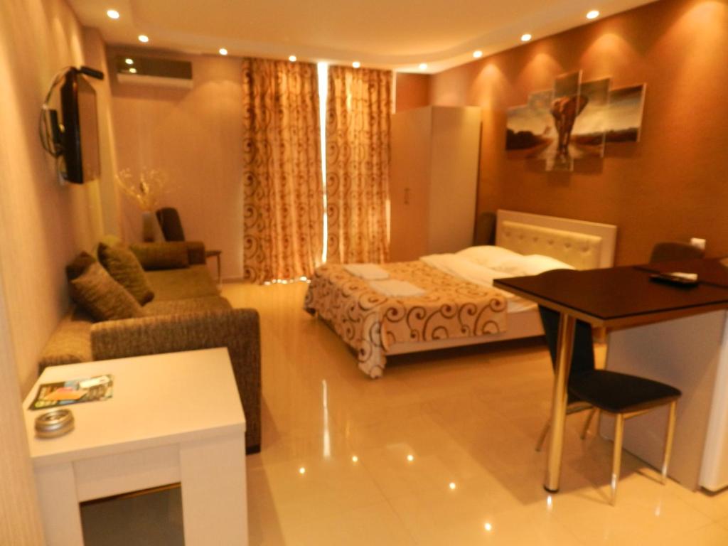 um quarto com uma cama, uma secretária e uma mesa em ApartHotel Calypso in Orbi em Batumi