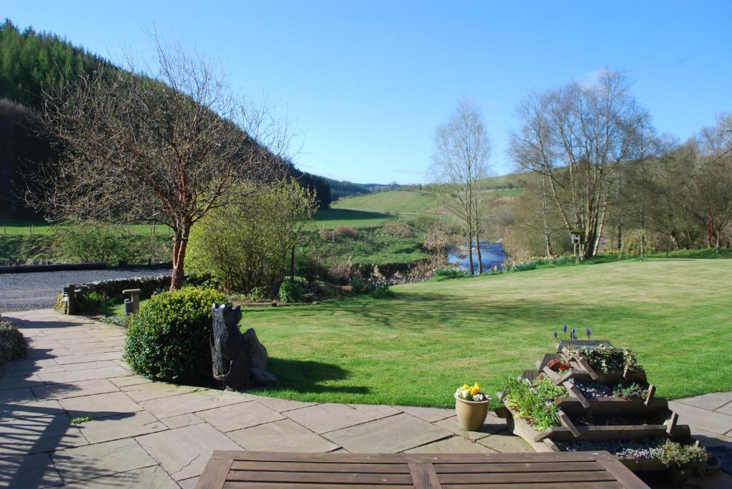 einen Garten mit einem Grasfeld und einem Hügel in der Unterkunft Green Hope Guest House in Ellemford