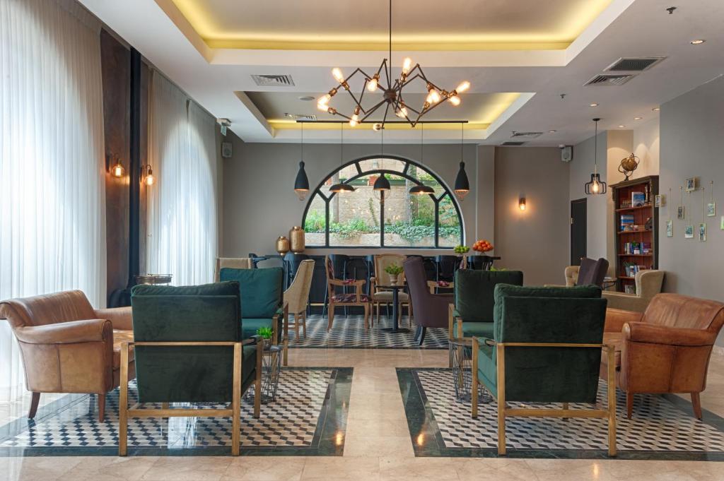 einen Salon mit Stühlen, einem Tisch und einem Fenster in der Unterkunft Eldan Hotel in Jerusalem