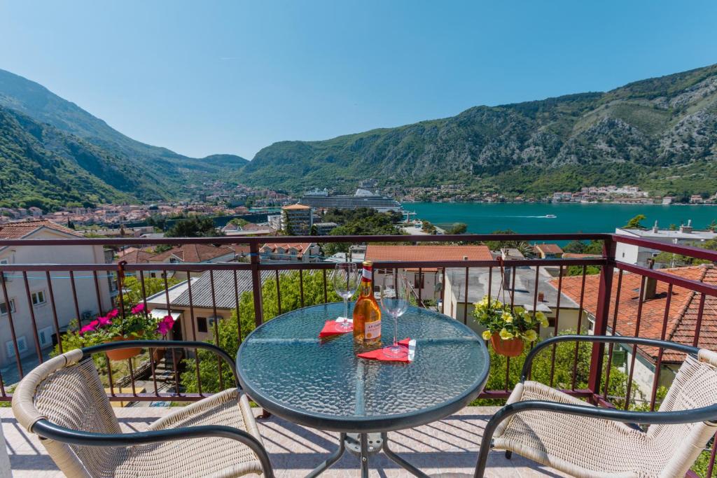 a table with a bottle of wine sitting on a balcony at Apartments Feniks in Kotor