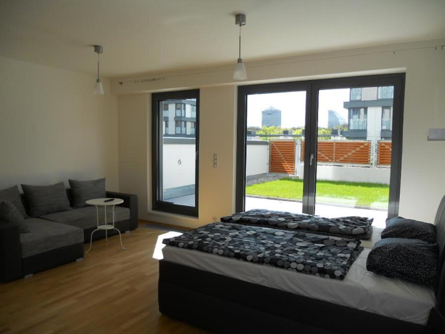 - une chambre avec un lit, un canapé et une grande fenêtre dans l'établissement Apartment David Garden Towers, à Prague