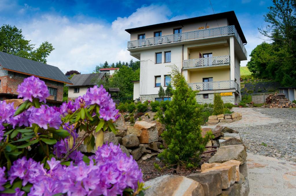 un edificio con flores púrpuras delante de él en Willa Vanilla, en Wisła