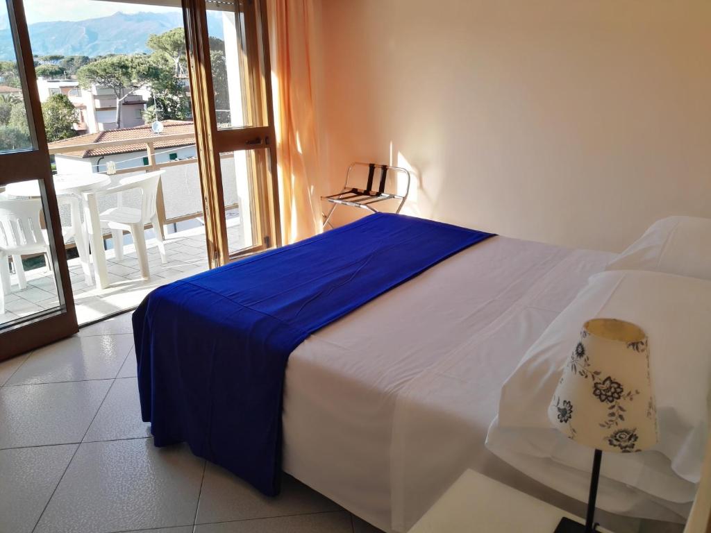 a bedroom with a bed and a view of a balcony at Hotel Elizabeth in Marina di Pietrasanta