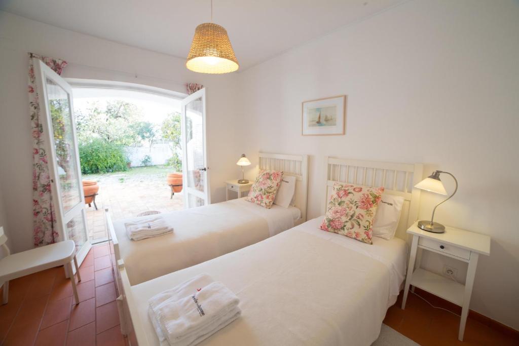 twee bedden in een kamer met een raam bij FLH Praia da Luz House with Terrace in Luz