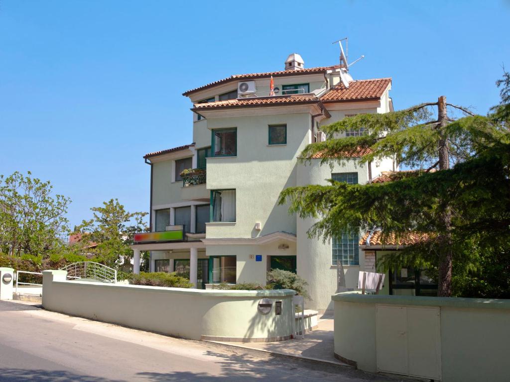 un grand bâtiment blanc sur le côté d'une rue dans l'établissement Apartment Emma, à Pula