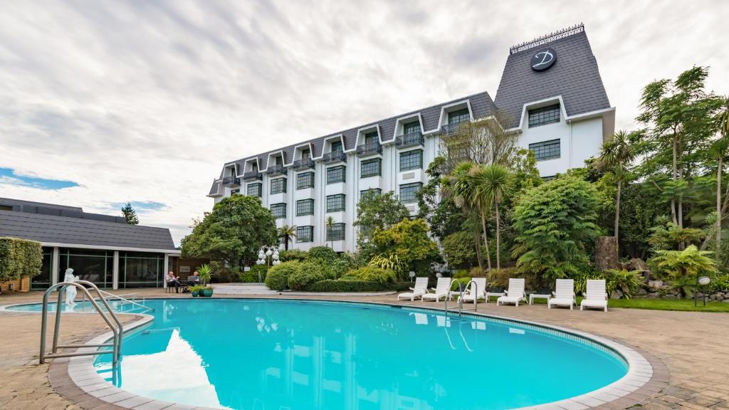 un hôtel avec une piscine en face d'un bâtiment dans l'établissement Distinction Hotel Rotorua, à Rotorua