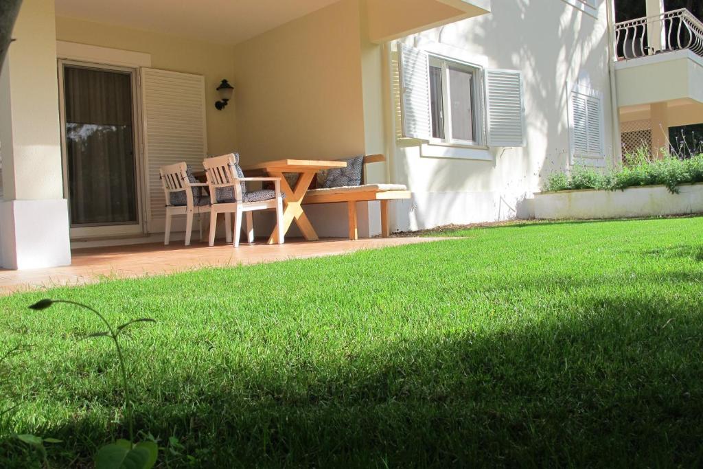 a patio with a table and chairs on a lawn at Quinta do Lago Golf in Quinta do Lago