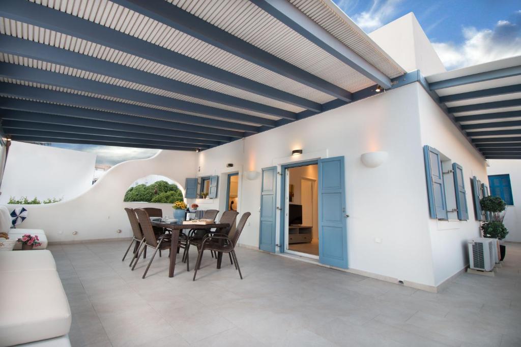 a dining room with a table and chairs on a patio at Villa Maria Naxos in Naxos Chora