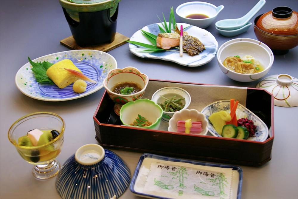una mesa con una caja de comida y platos de comida en Kinparo, en Kioto