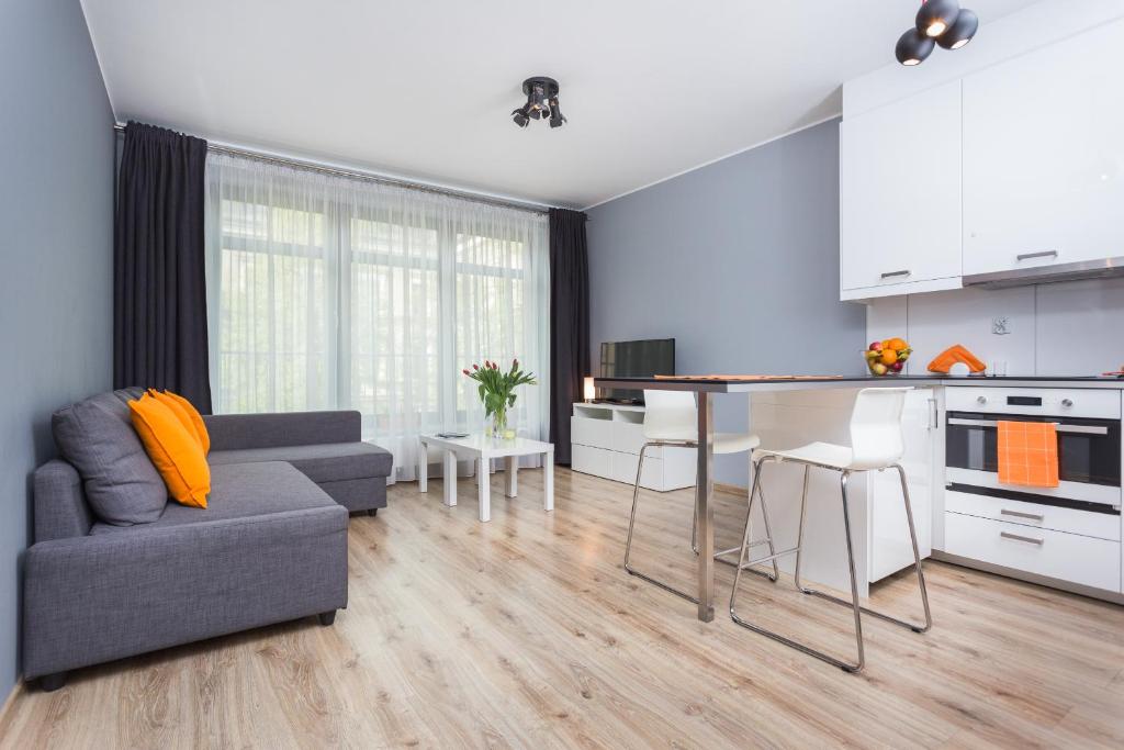 cocina y sala de estar con sofá y mesa en Apartamenty Lucky 13, en Cracovia