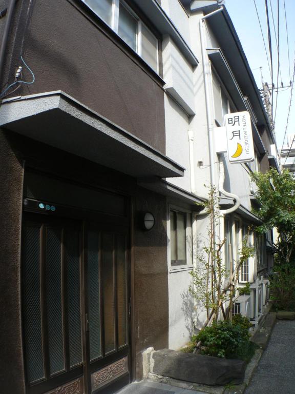 una entrada a un edificio con un cartel en él en Hotel Meigetsu, en Tokio