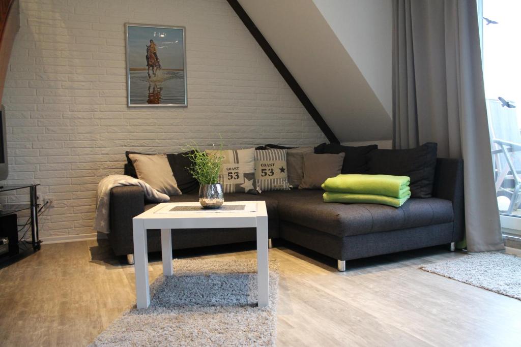 uma sala de estar com um sofá e uma mesa em Appartement Bilbao em Sankt Peter-Ording